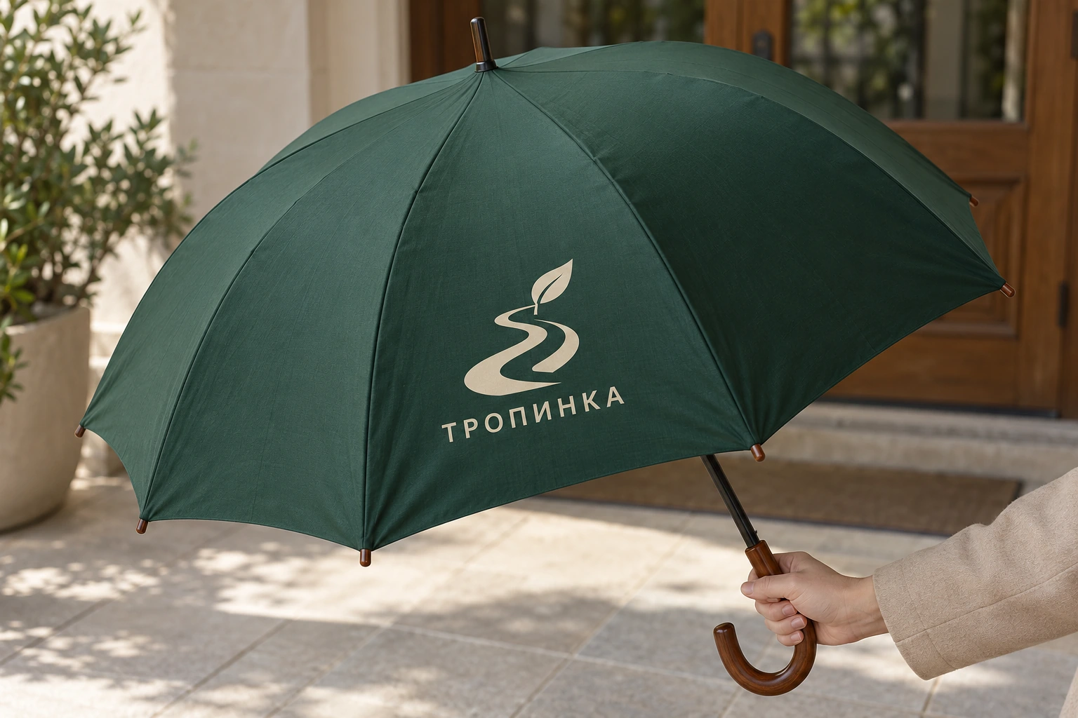Раскрытый зелёный зонт «Тропинка» со светлым логотипом между швами купола